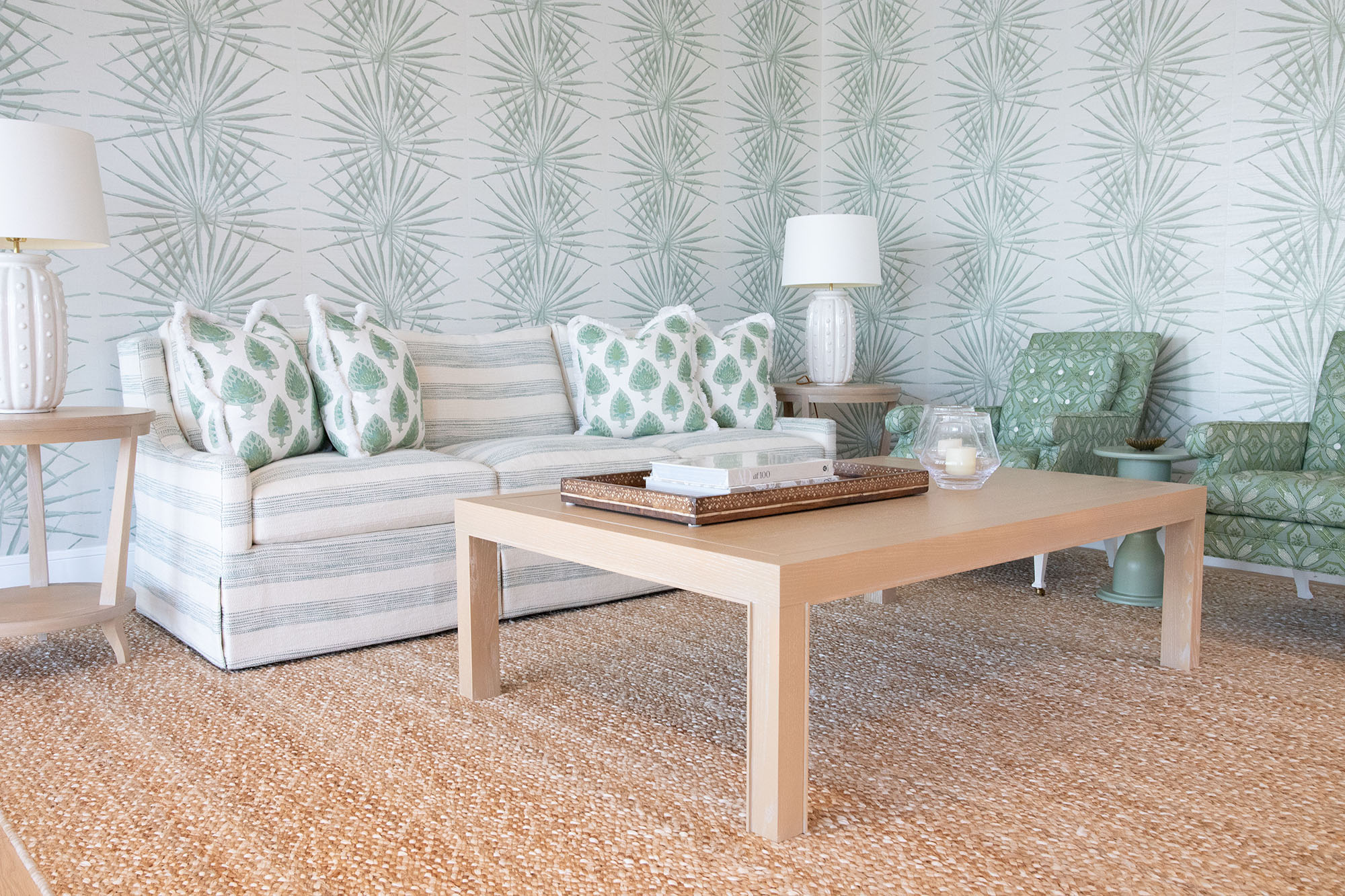 image of hive trade showroom living room grouping with palm wallpaper and green and white upholstered sofa and chairs