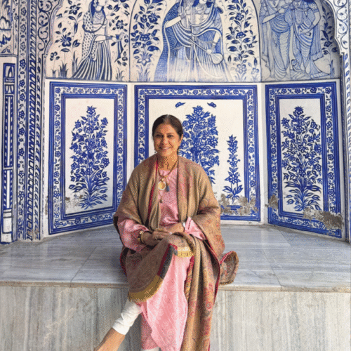 woman sitting in front of alcove covered in blue and white tiles